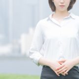 お腹を押さえる女性