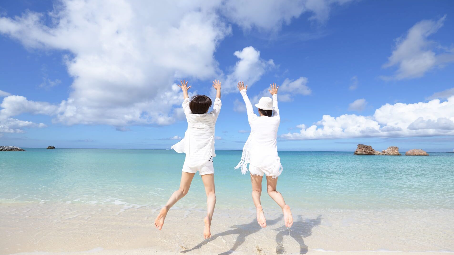 浜辺でジャンプしている女性二人