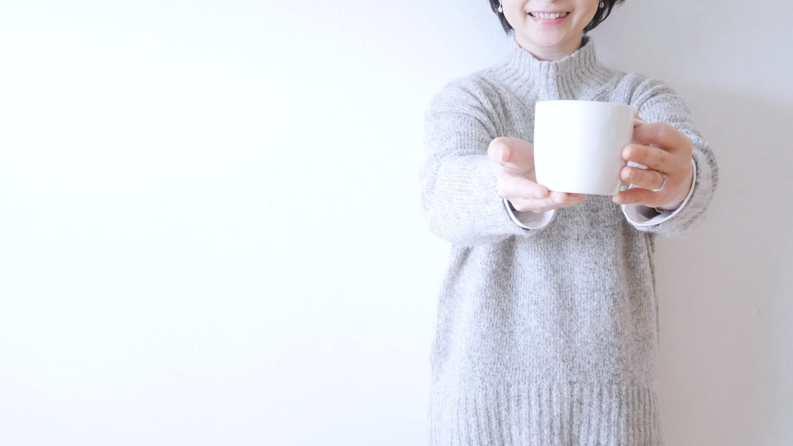 マグカップに入ったお茶を勧める女性