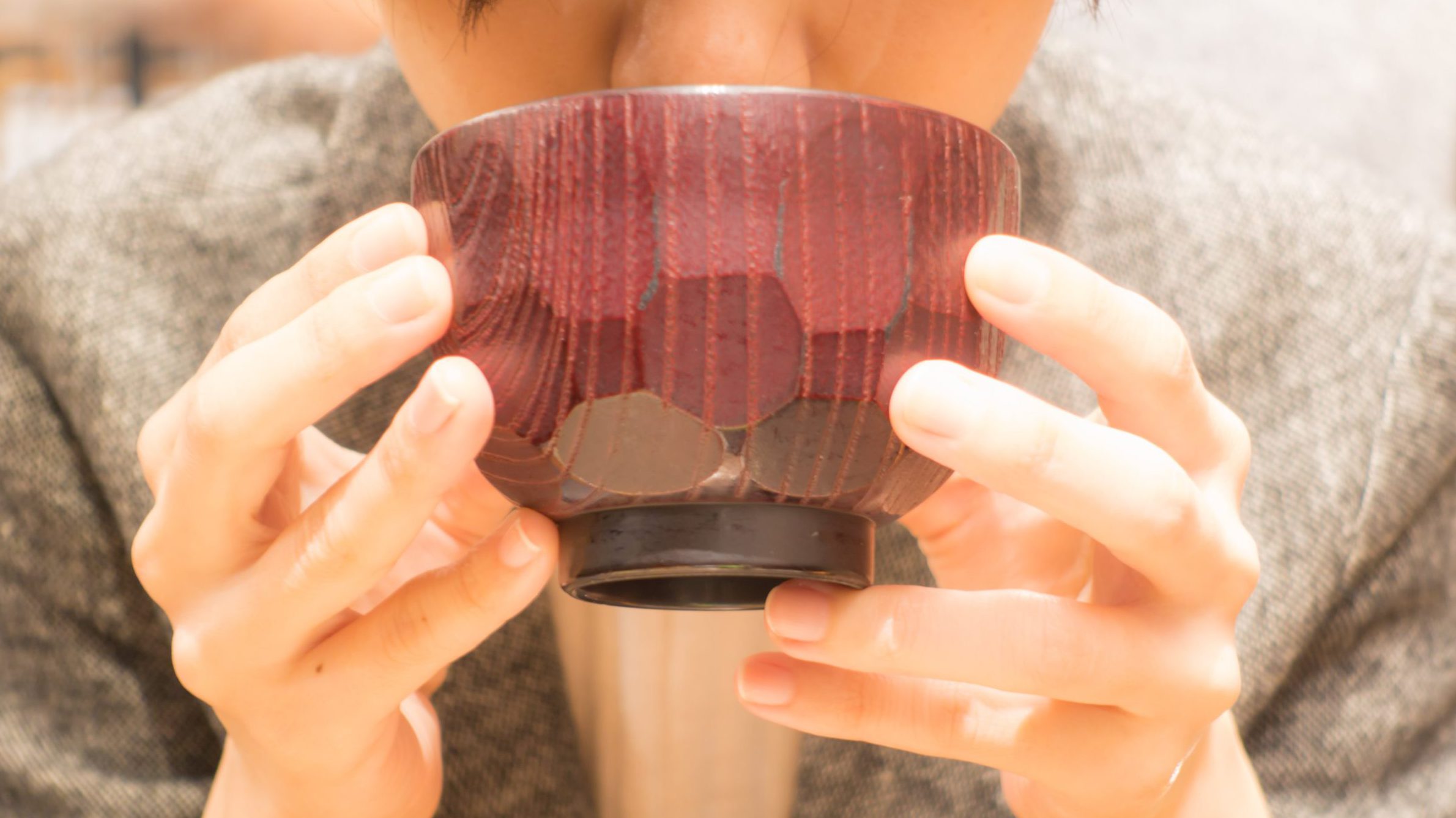 味噌汁を飲む女性